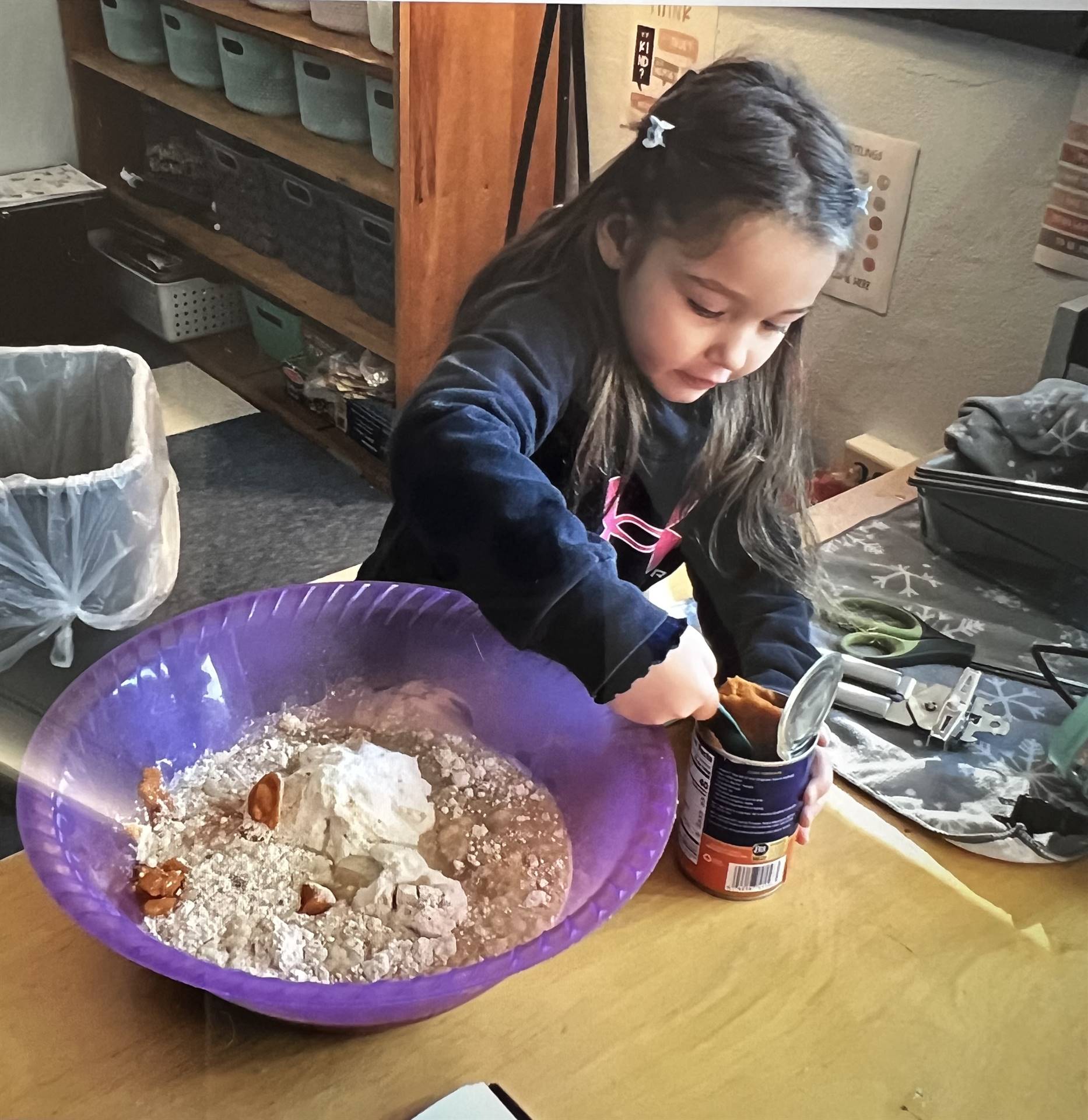 a student cracks an egg into a bowl for a batter.