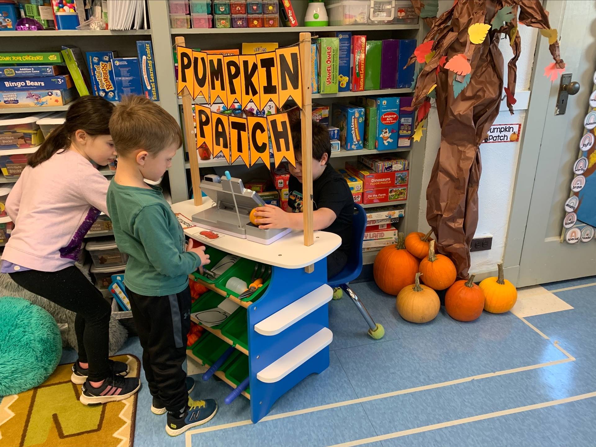 students buddy up to play in the play pumpkin patch.