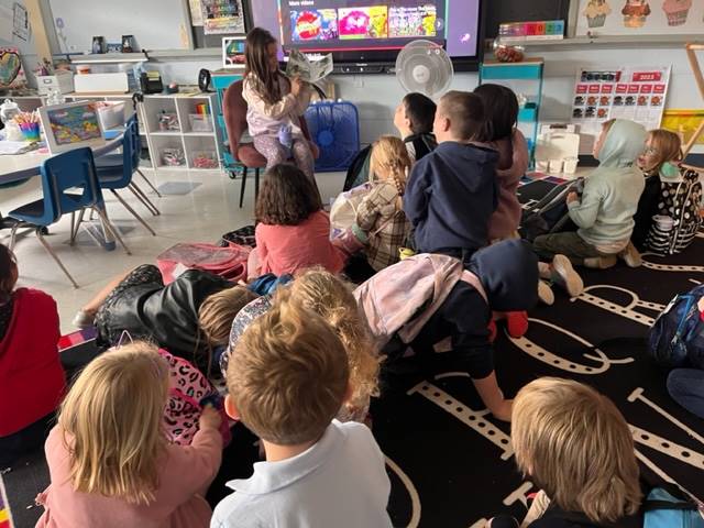 a first grader reads a book to her class