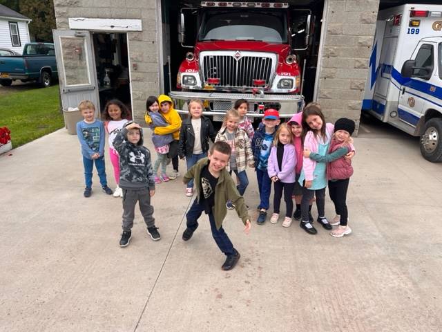 a group of students standing in front of the fire station