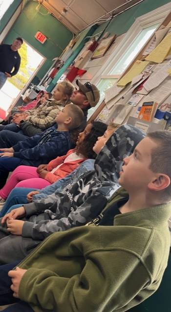 a group of students sitting inside a fire station