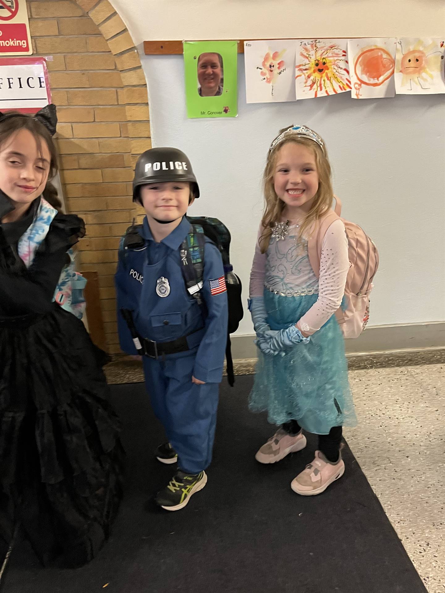 2 students dressed up. 1 police officer and other Elsa