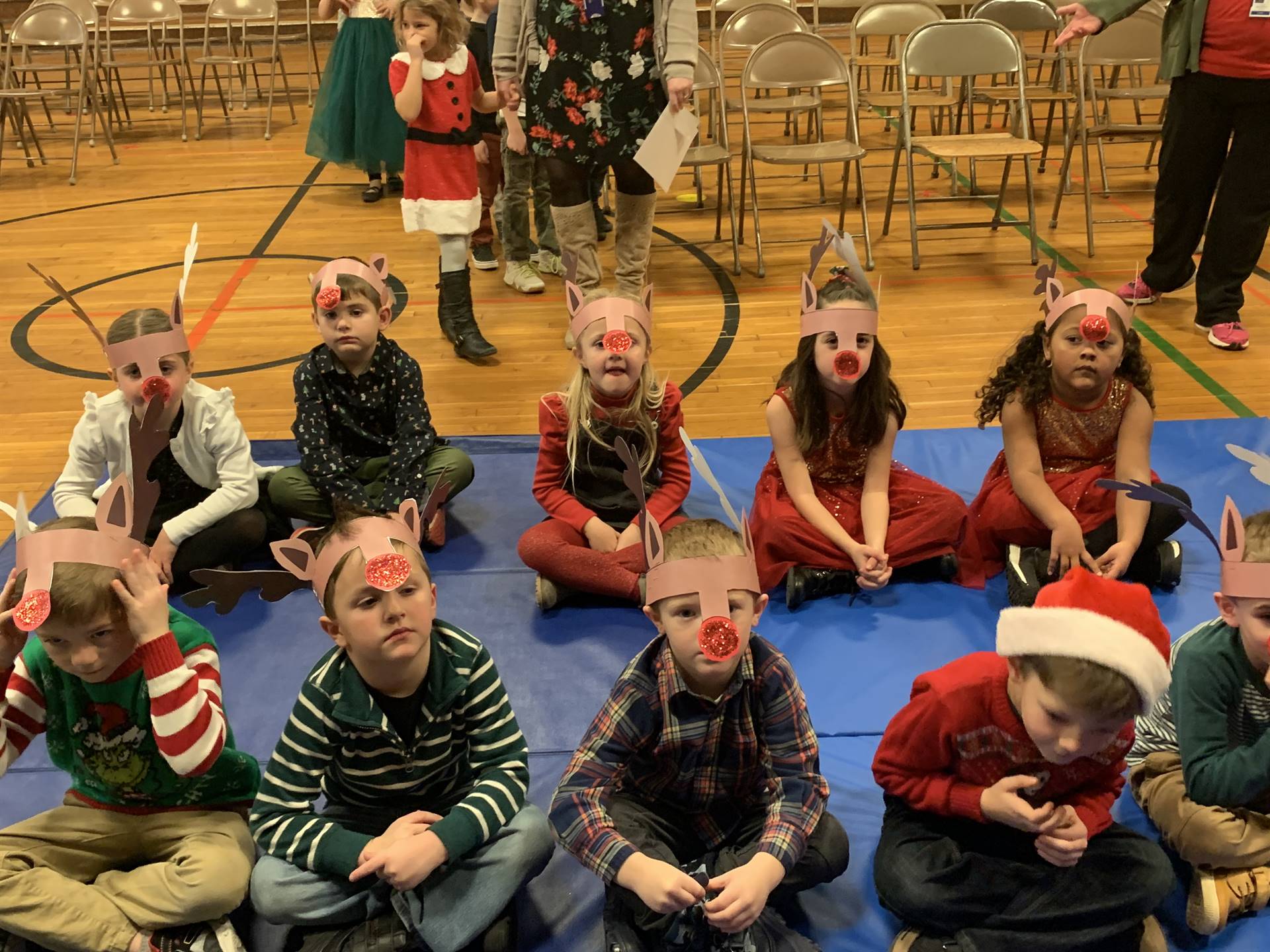 students sitting with red noses and reindeer ears