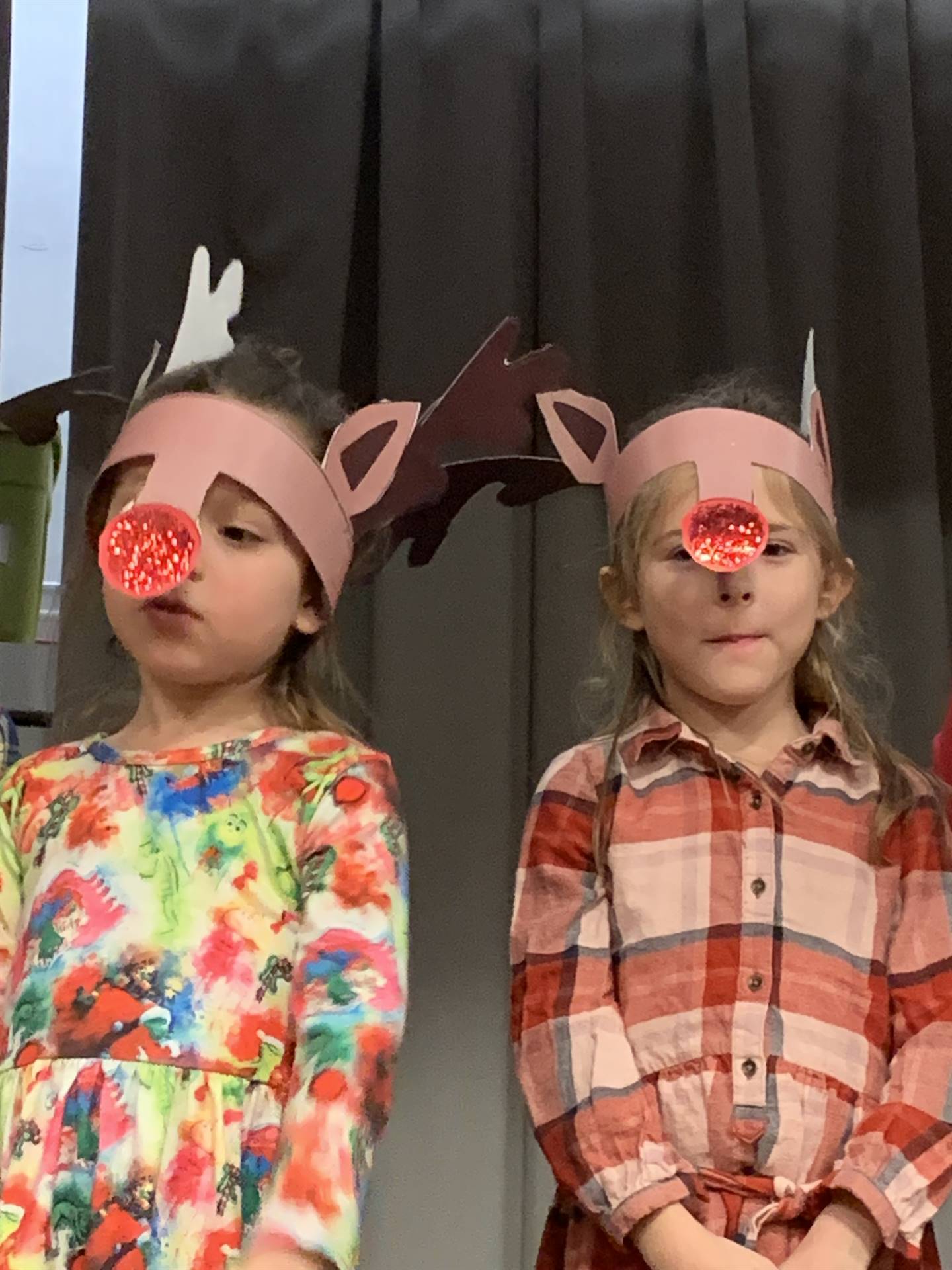 a pair of students with red noses and reindeers ears.