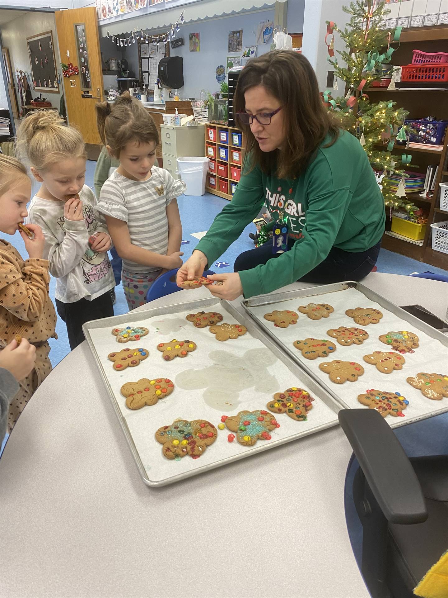 students decorating tray of gingerbread cookies.