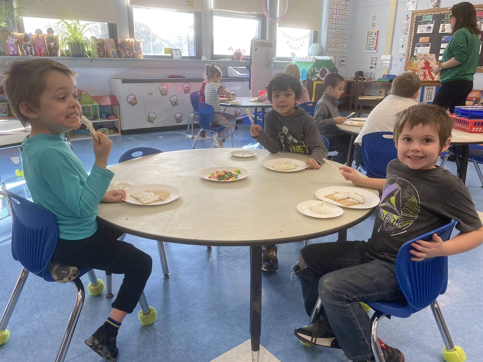 students decorating gingerbread houses. 