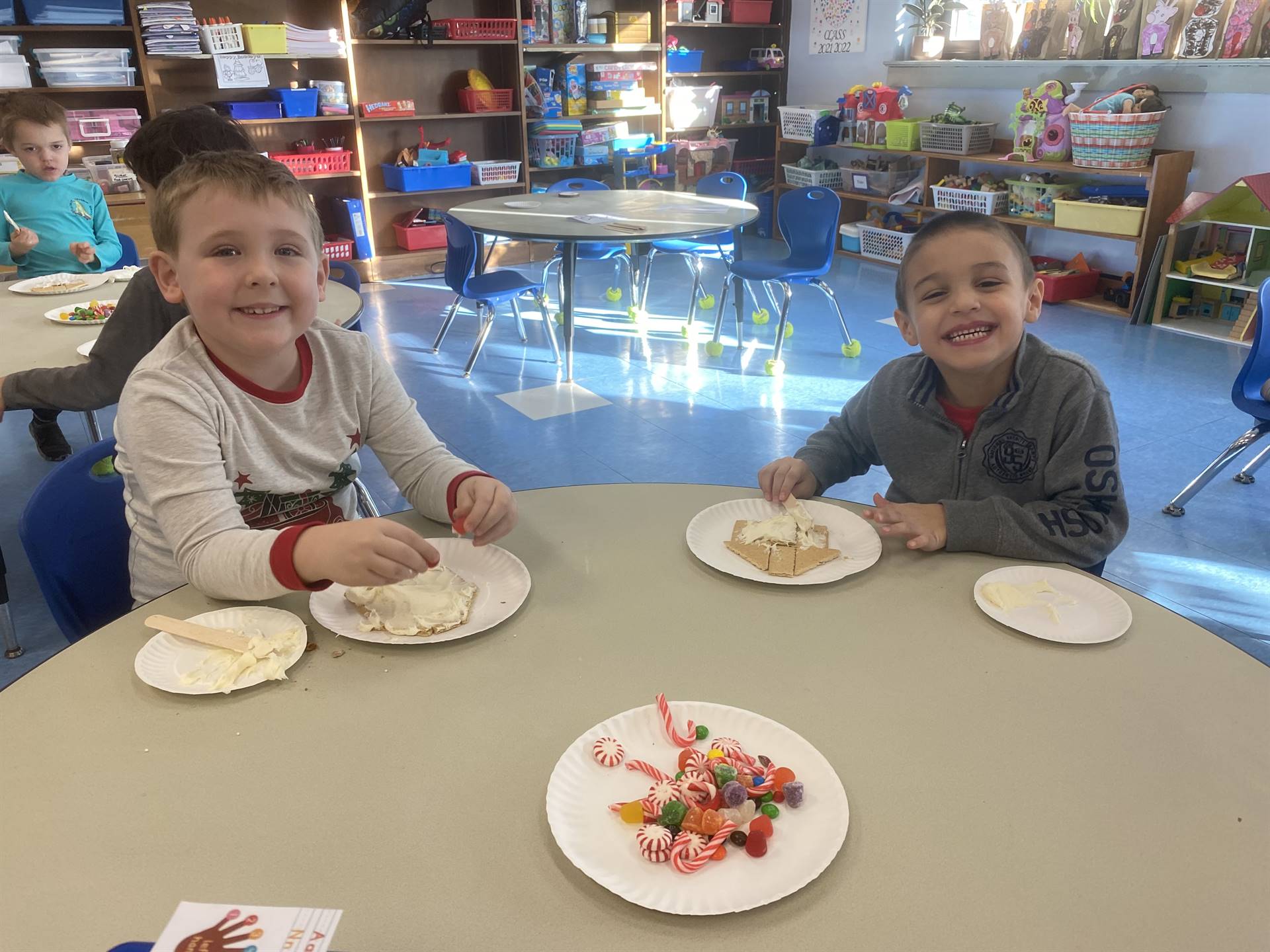 students decorating gingerbread houses. 