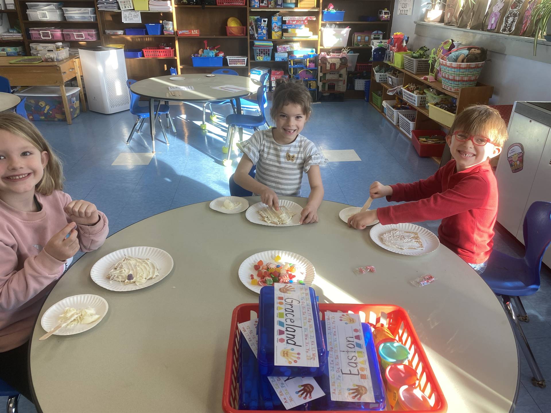 students decorating gingerbread houses. 