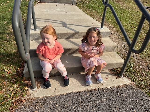 2 students outside siting on steps.