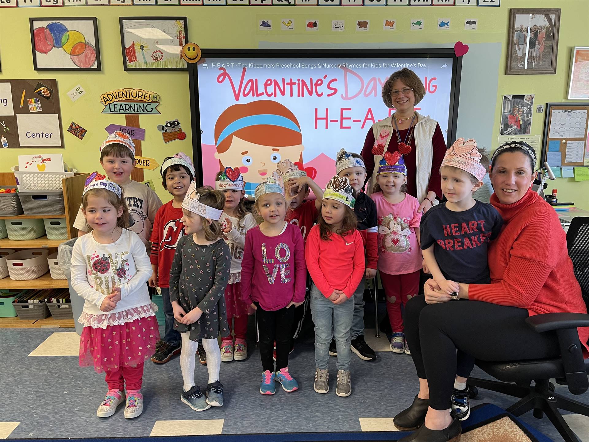 students with heart hats and 2 staff members.
