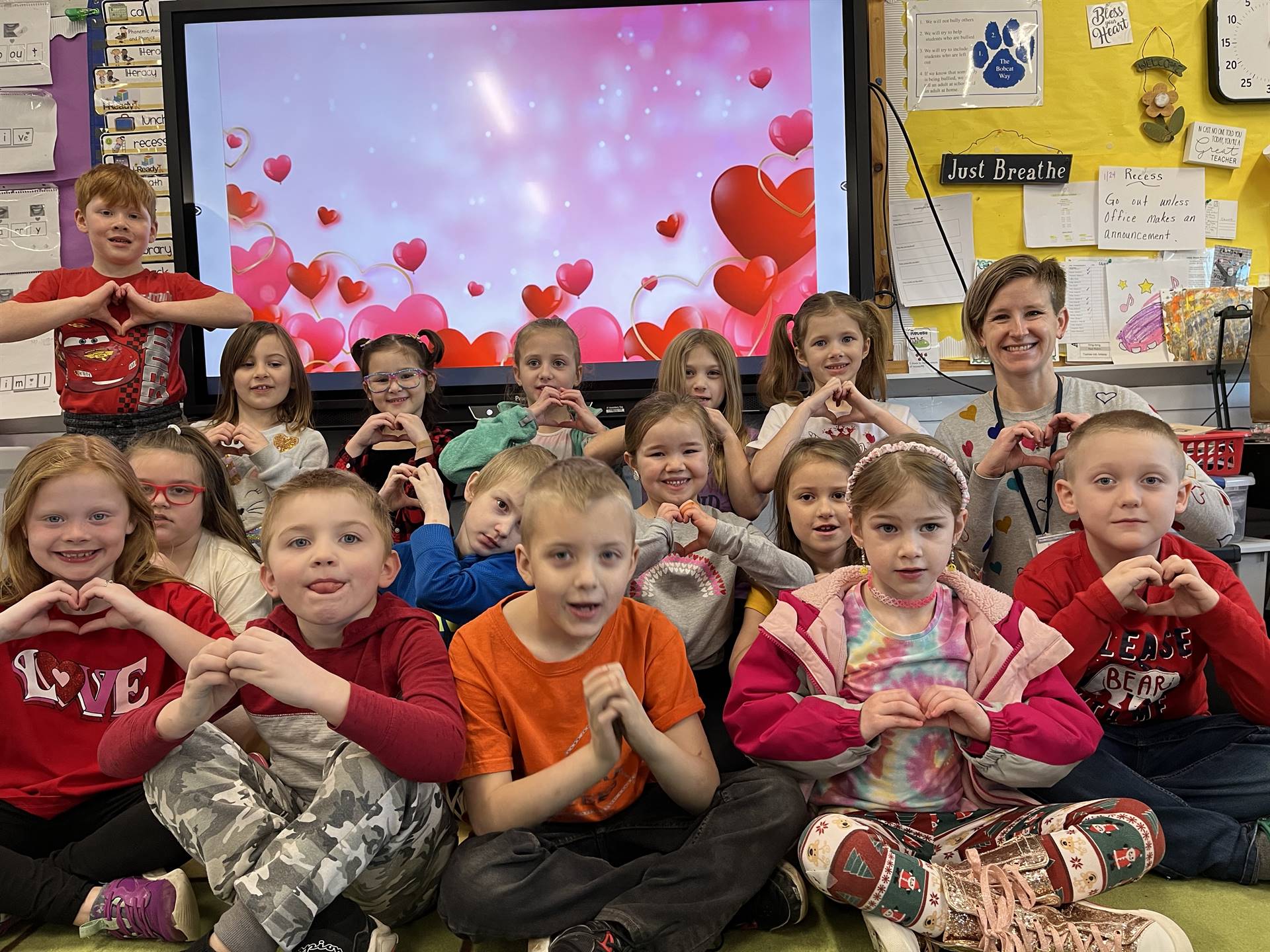 students making hearts with hands and hearts background.
