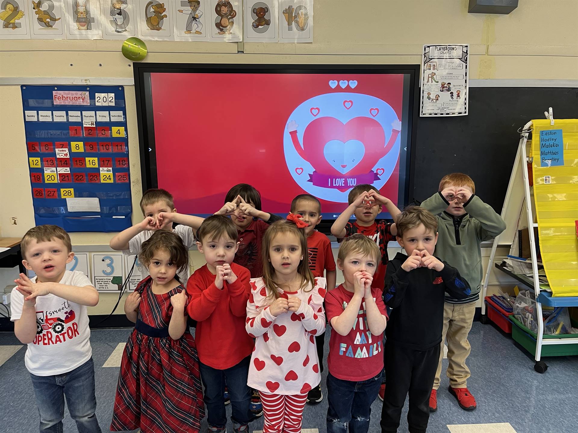 students making hearts with hands. 