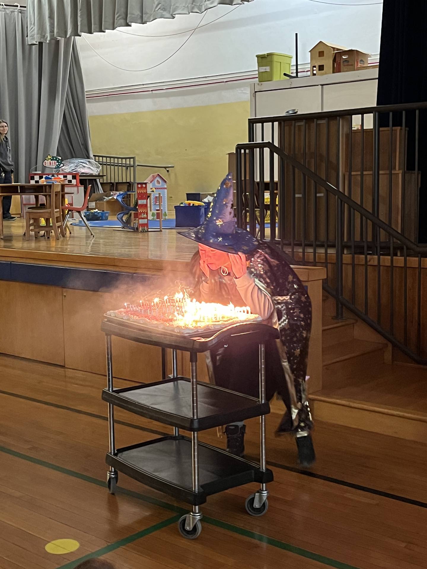 a person dressed as a wizard blowing out candles.