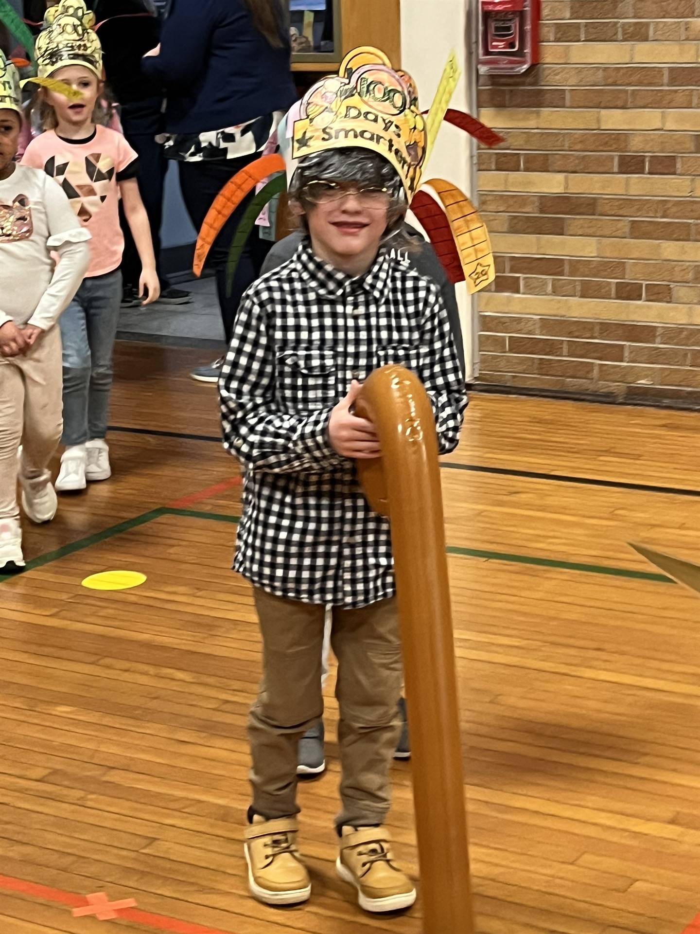 a boy dressed as 100 years old carrying a cane
