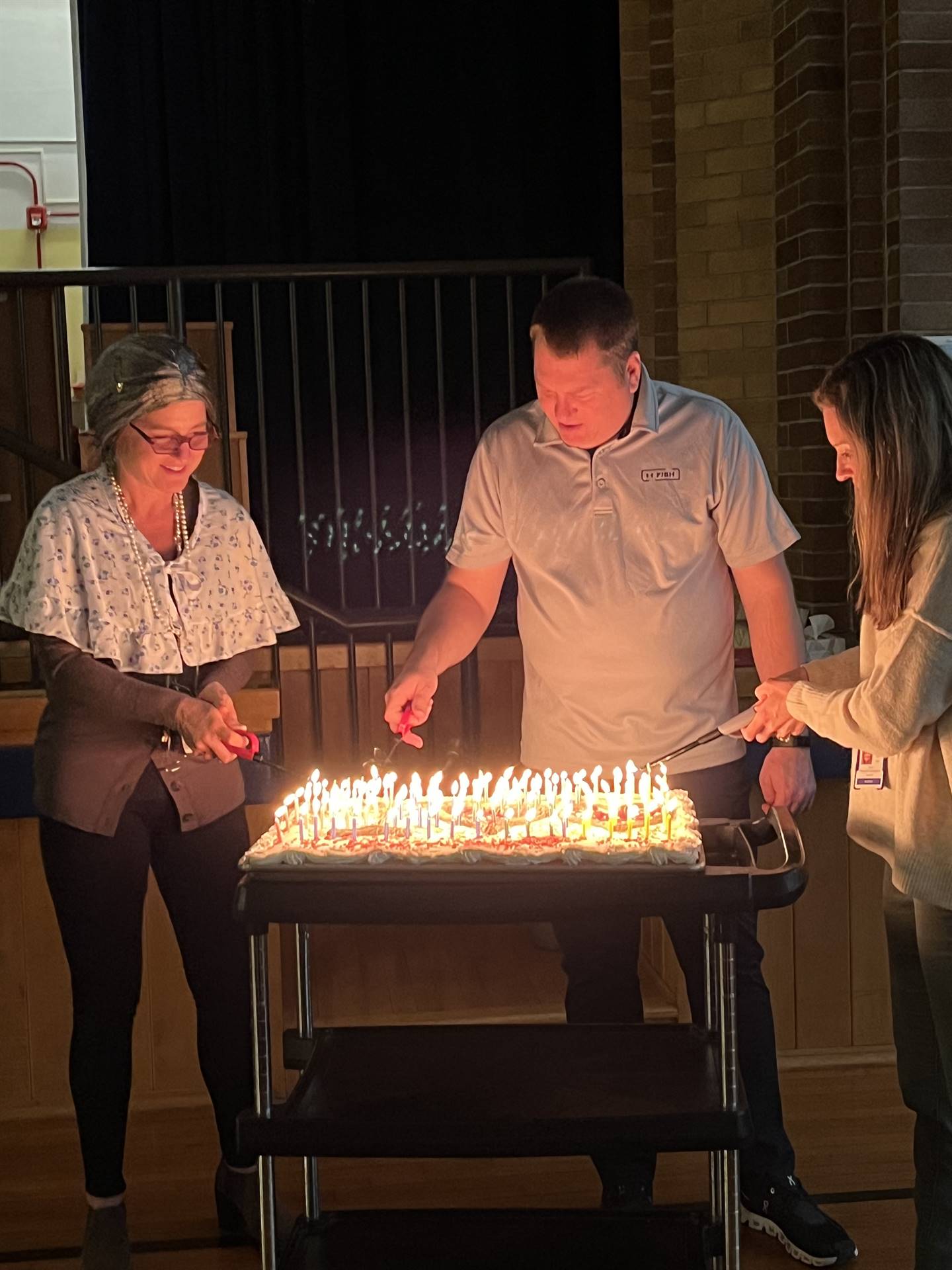3 teachers light 100 candles on a cake