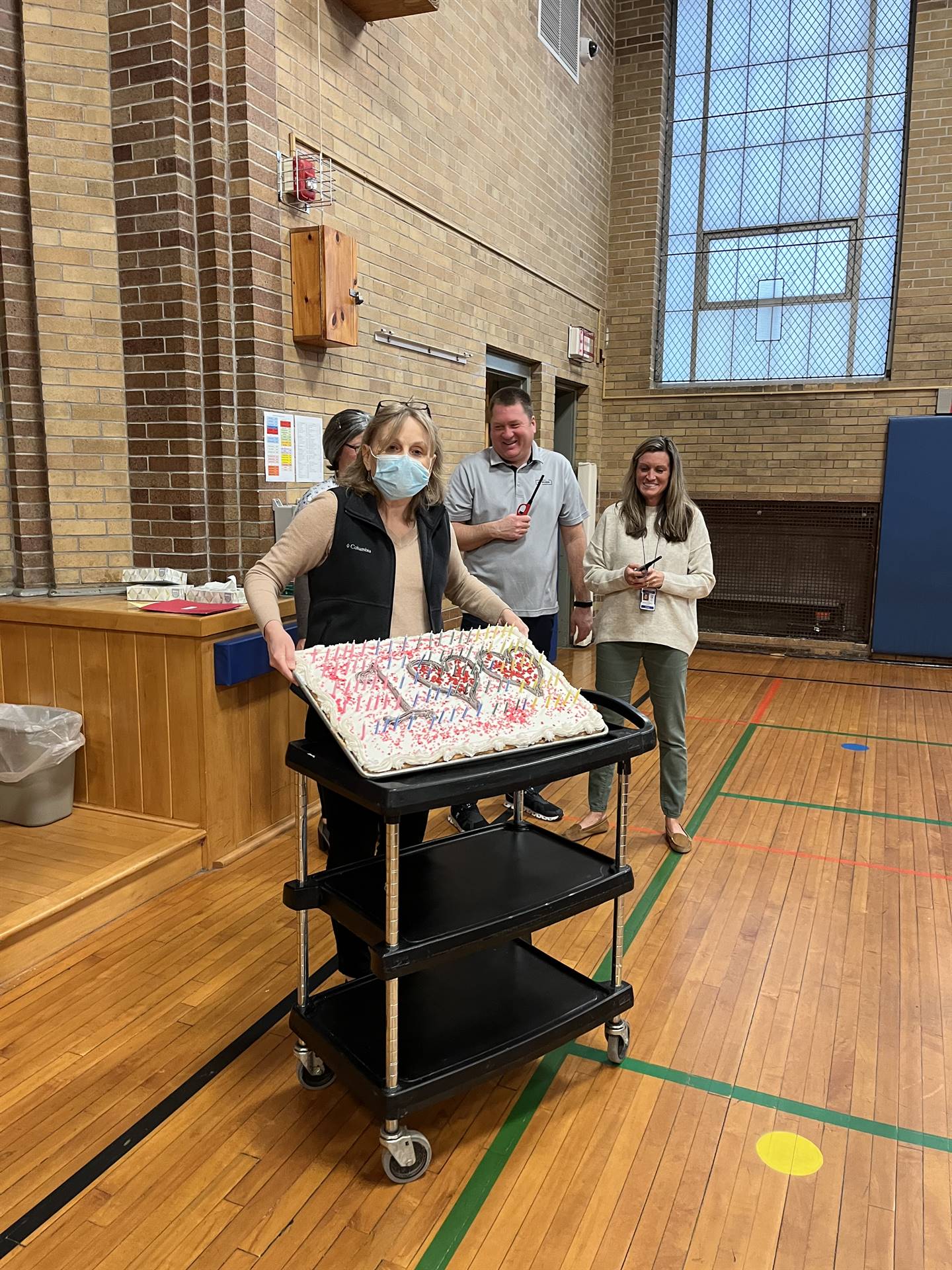 a teacher holds a 100 cake