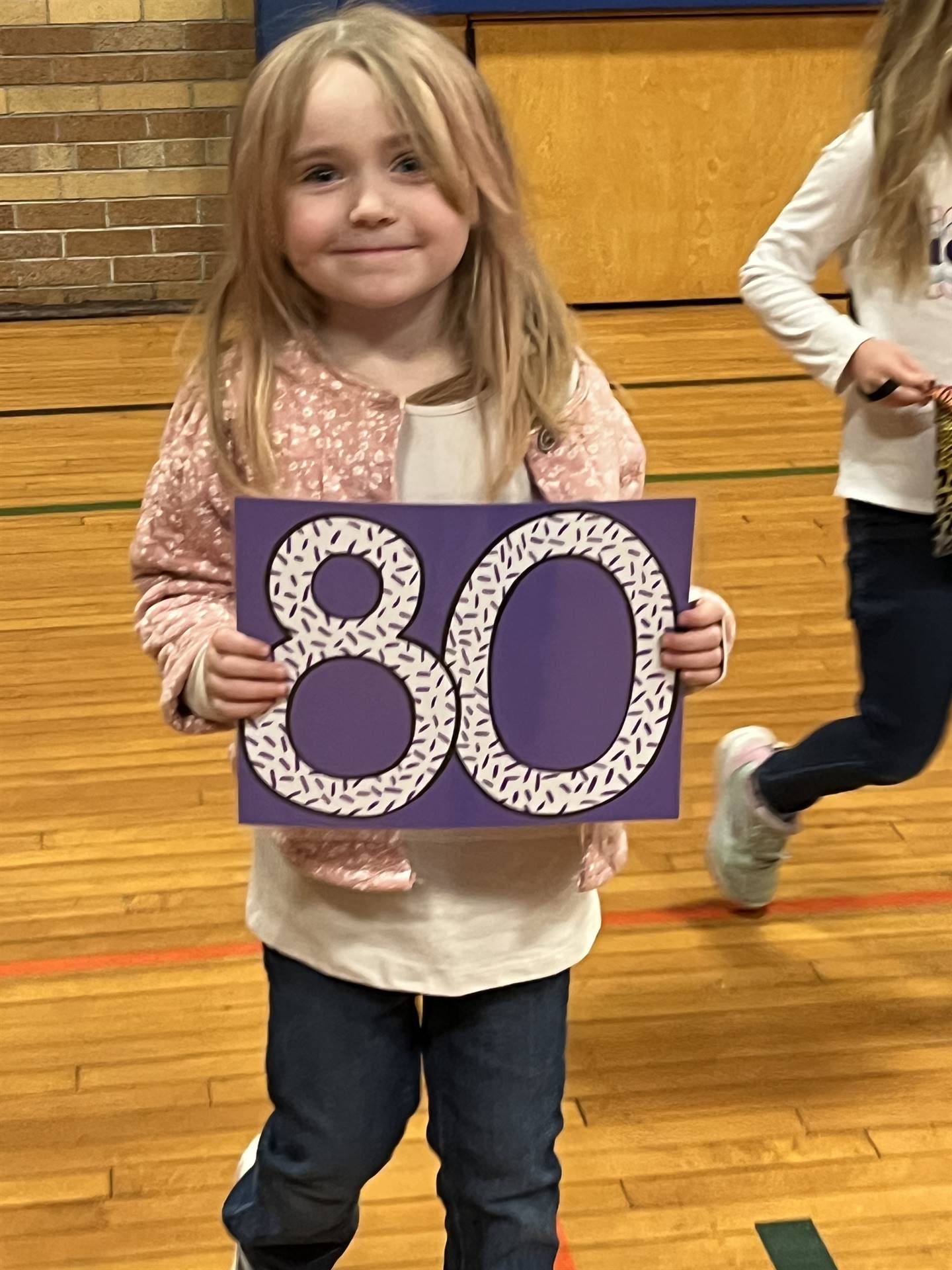 a student holds a 80 sign