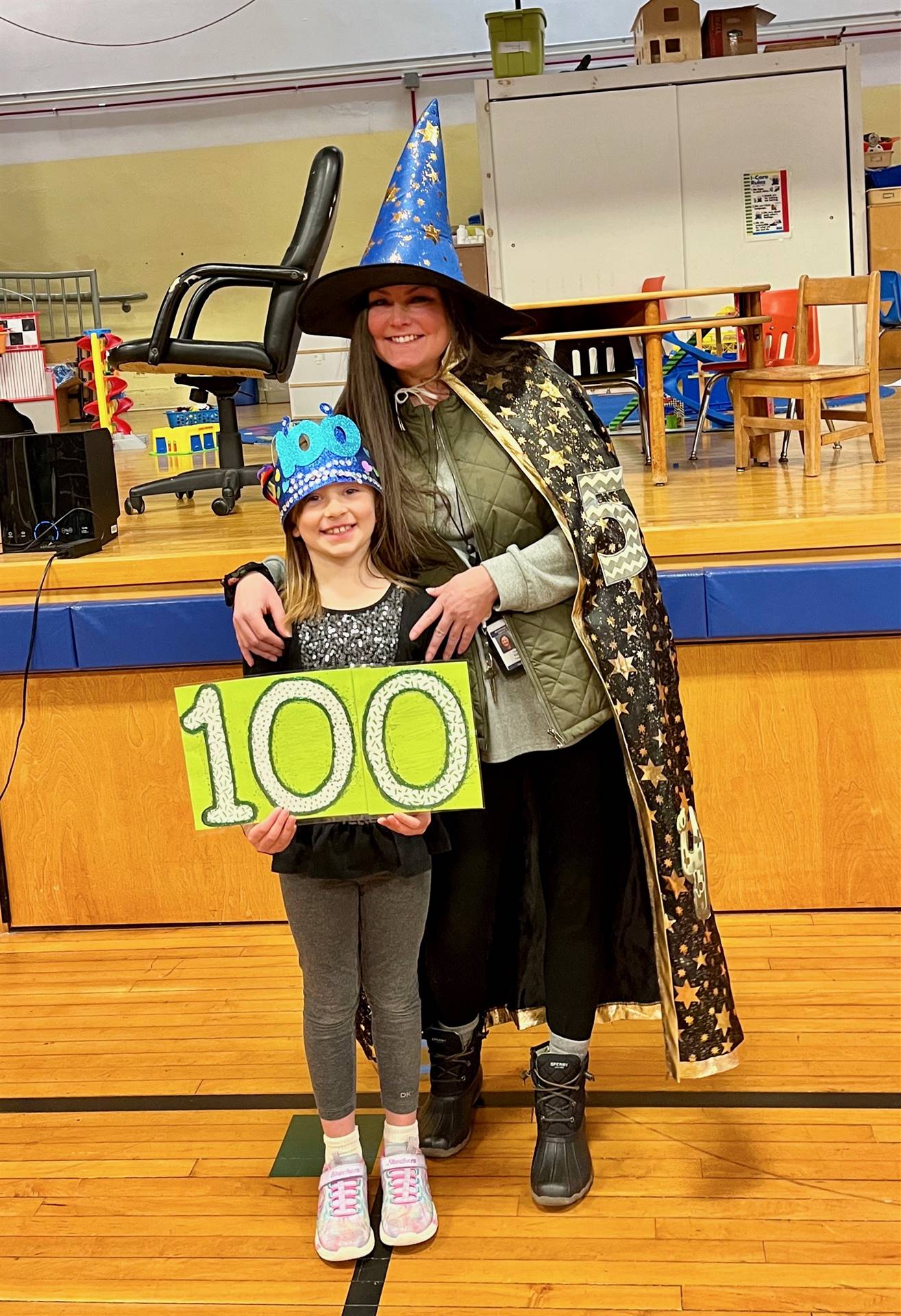 A wizard and student holding 100 sign