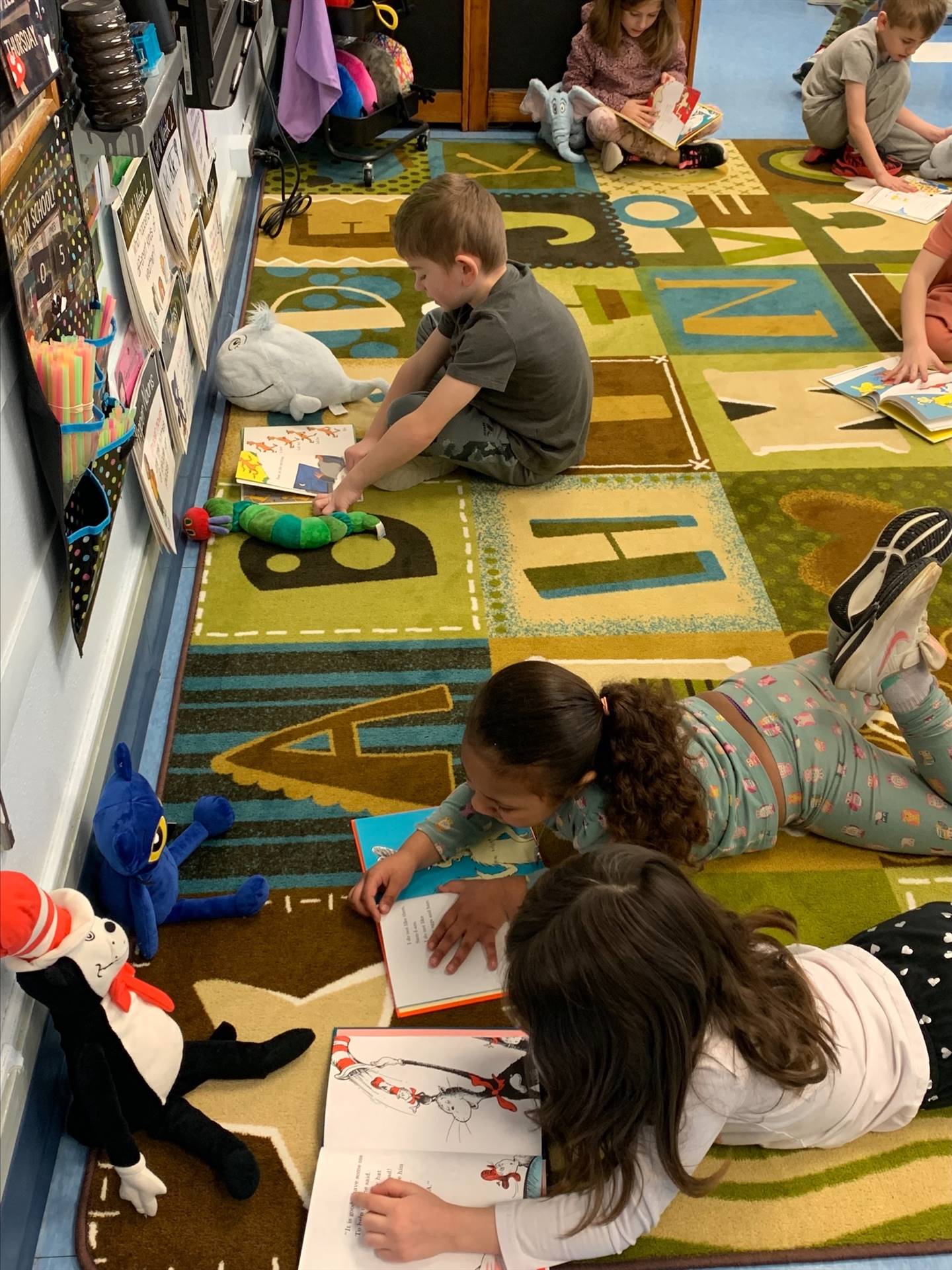 students laying down reading books to Cat in the Hat