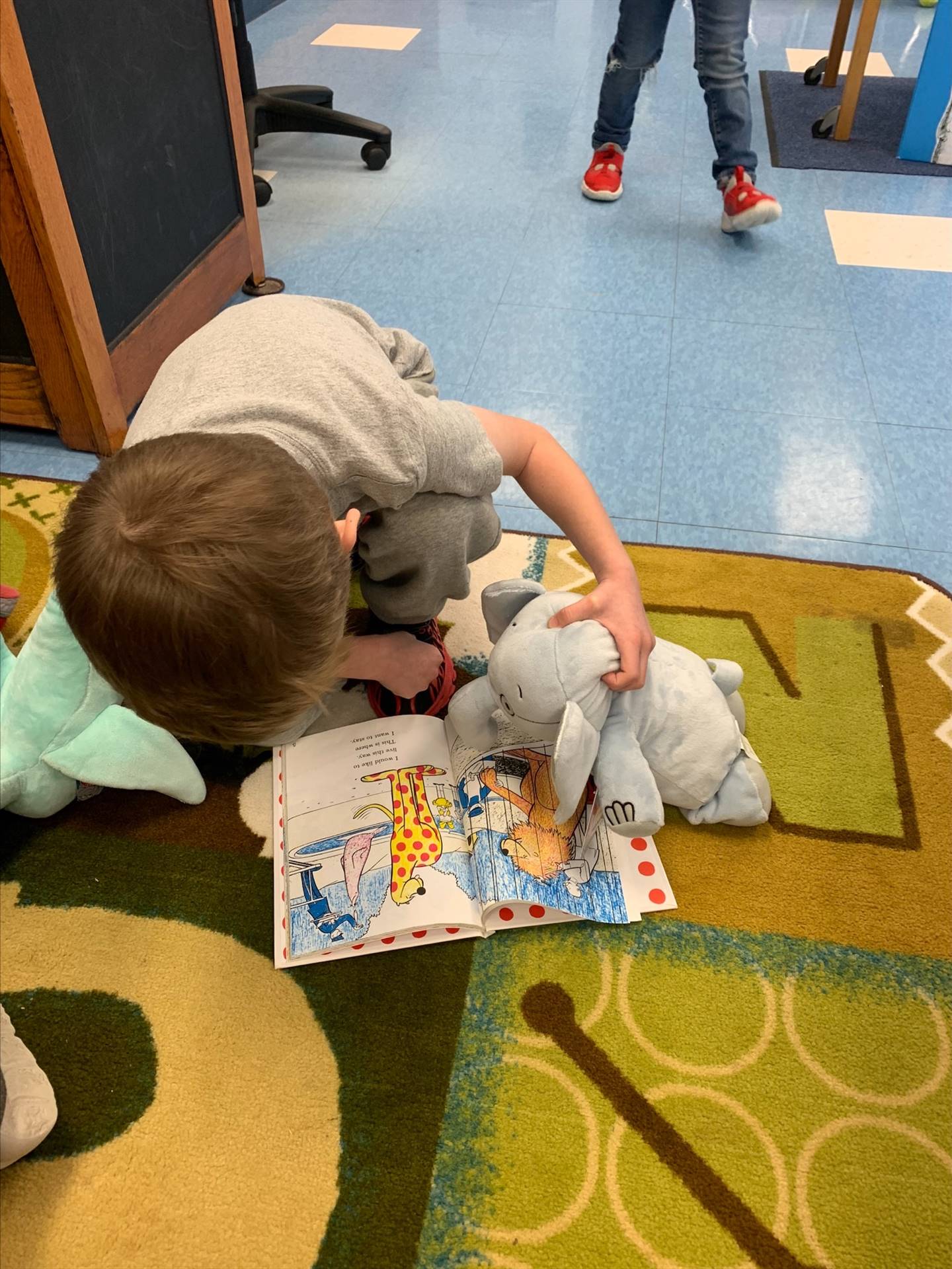 students reading books to stuffed animals