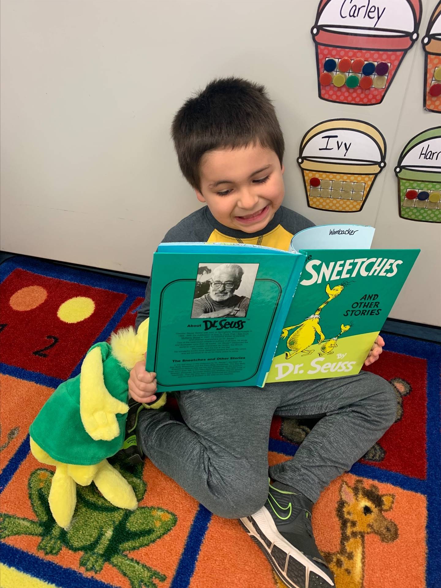 a student  reading books to a stuffed animal
