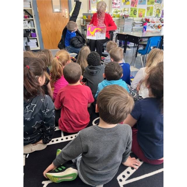 a grandmother guest reader reads to a class