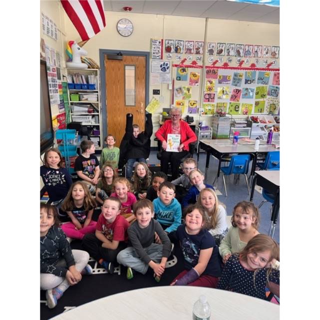 A class poses with their guest reader