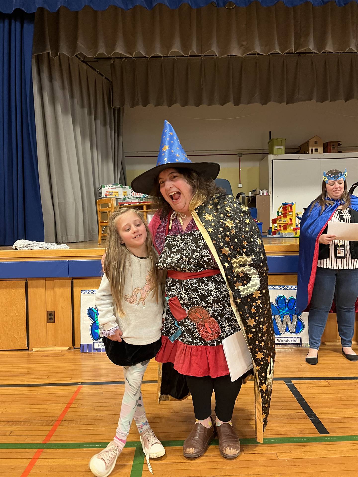 a student with a staff member dressed in wizard outfit