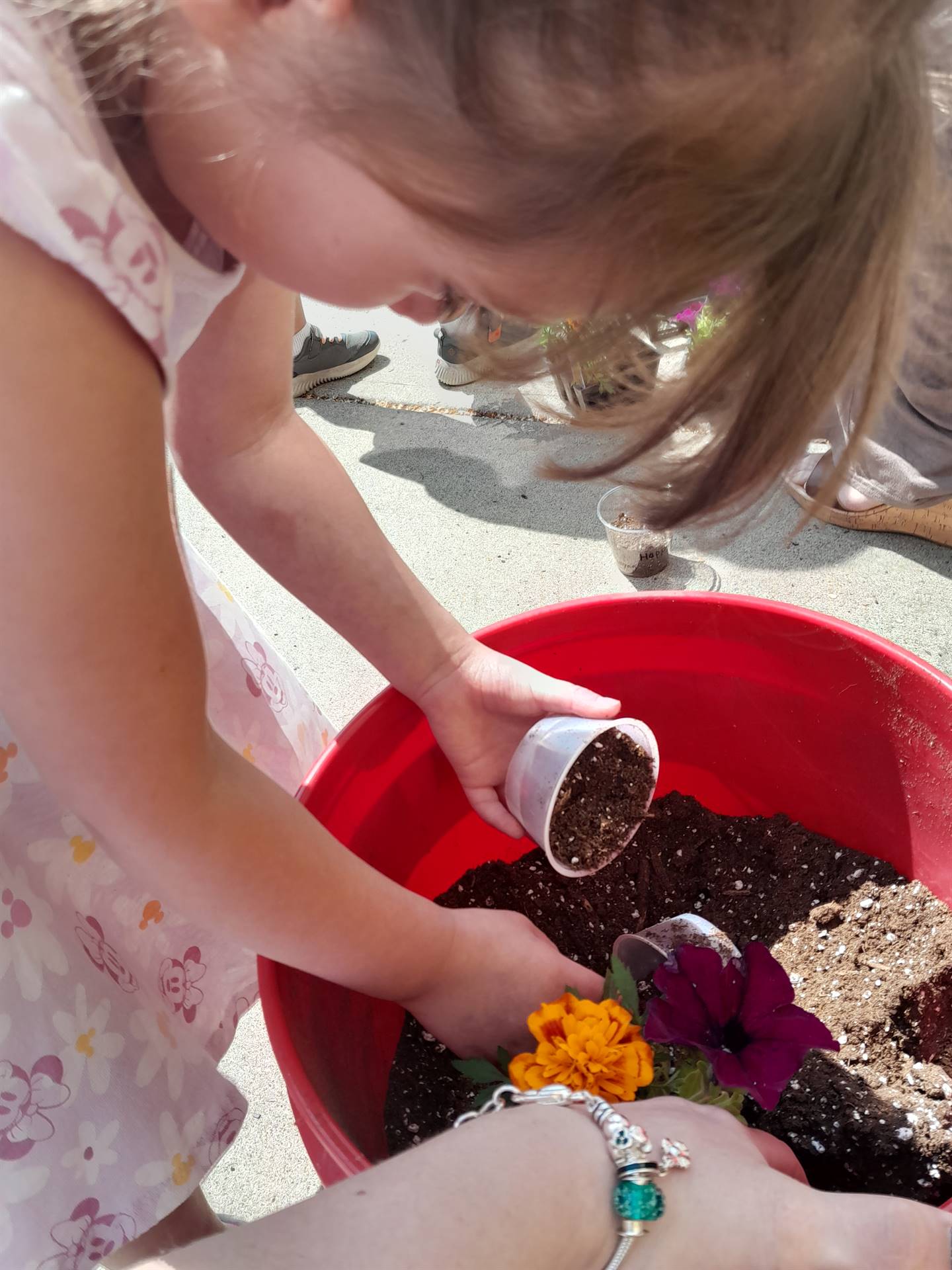 a student is digging soil from a bucket