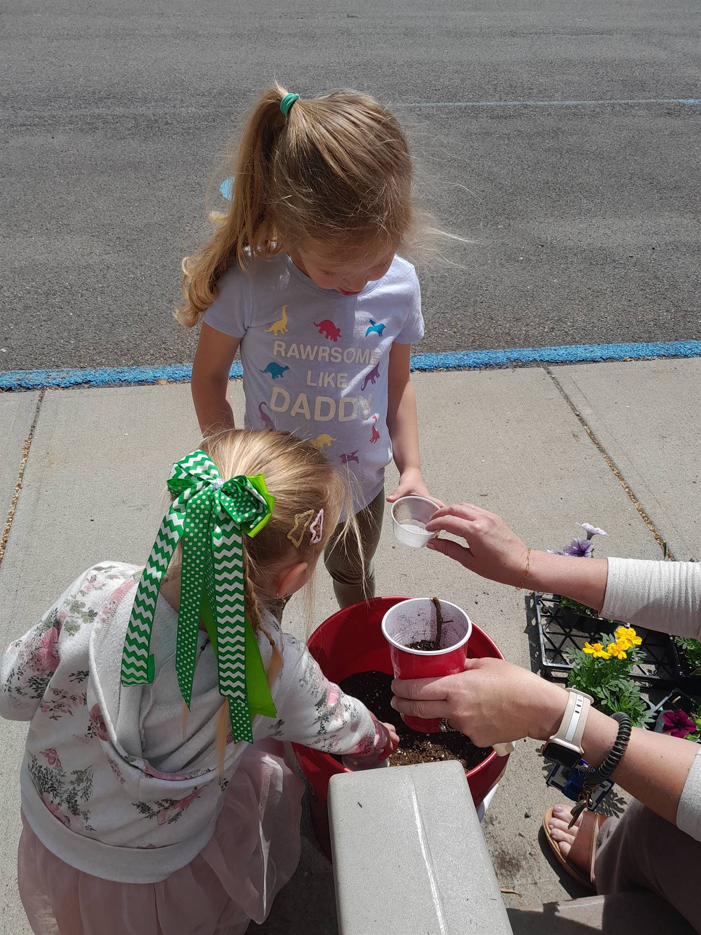 2 students are digging soil from a bucket