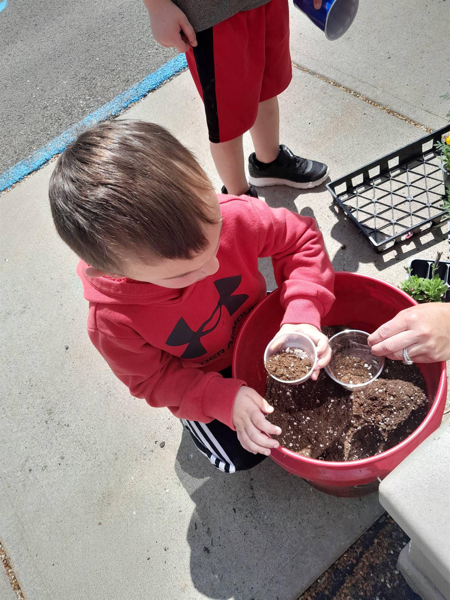 a student scoops soil from a bucket
