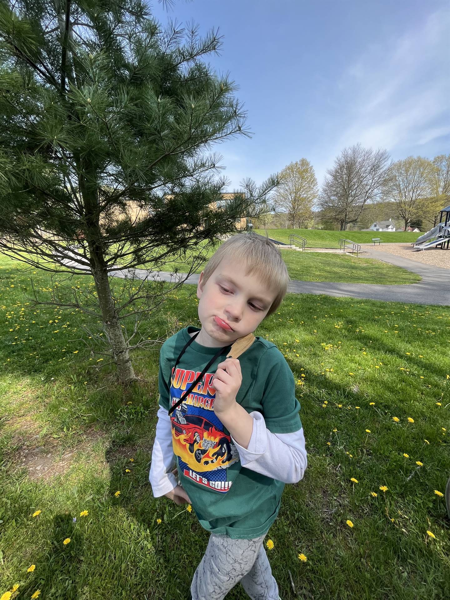 a student holds up a nature find next to his face