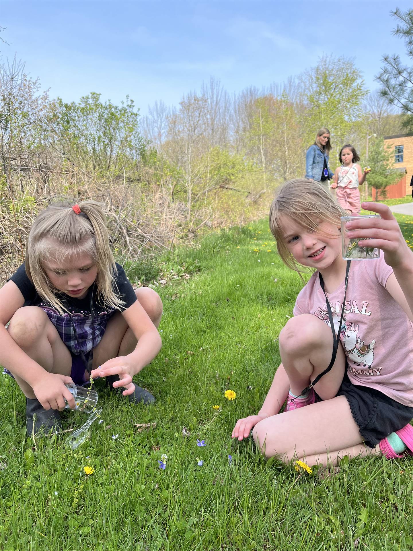 students outside on grass picking flowers