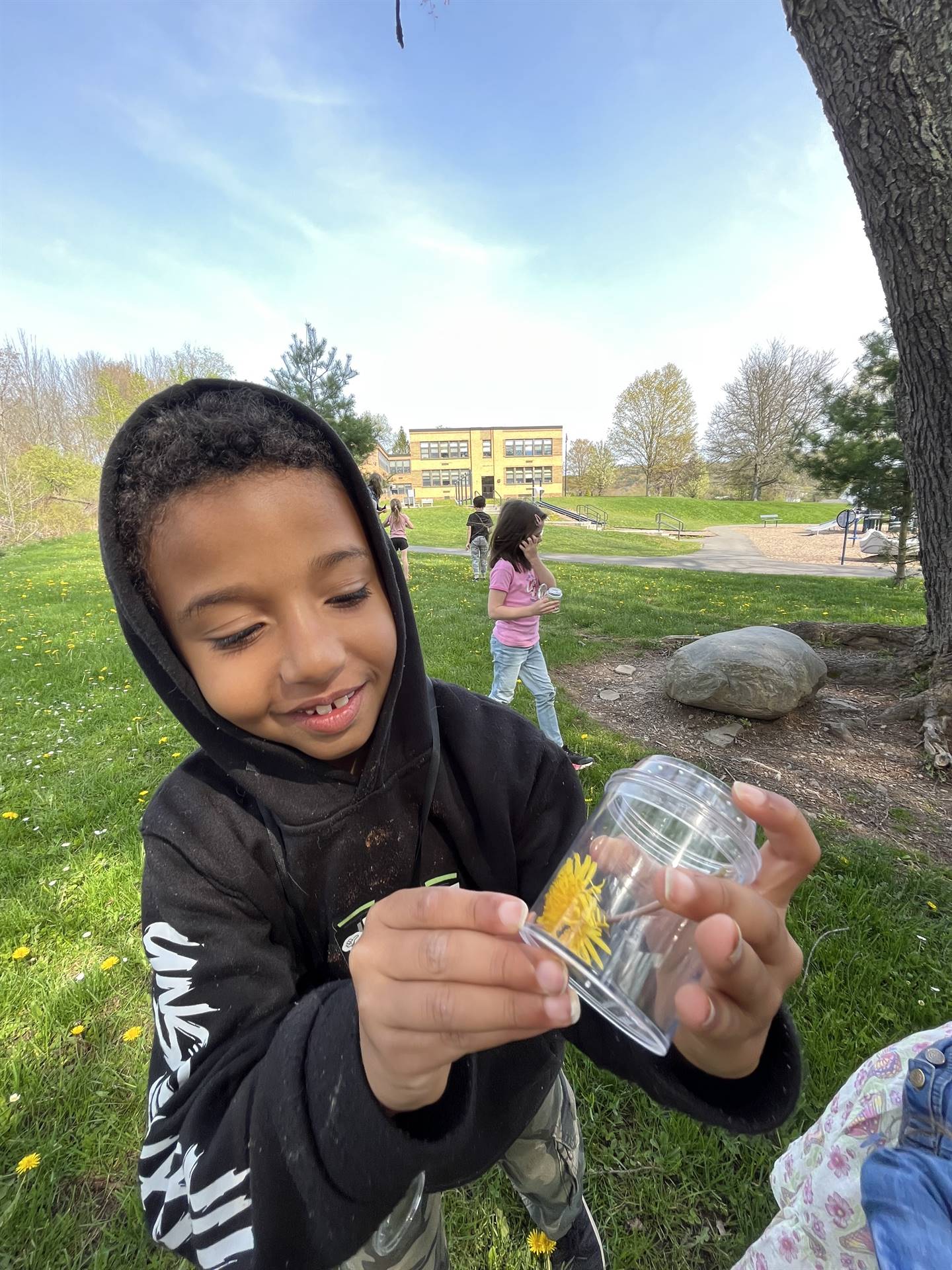 a student holds up a container of nature finds