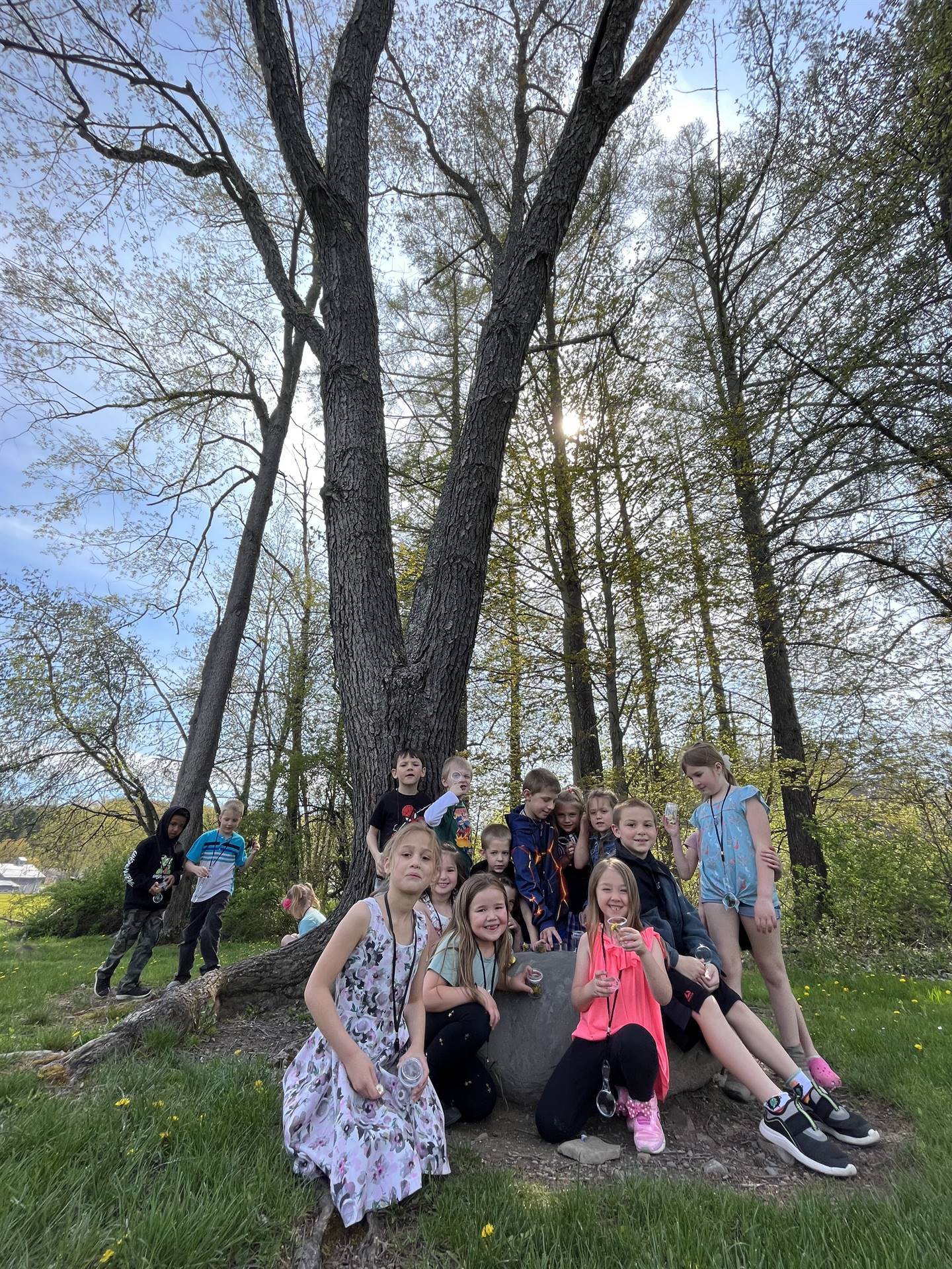 a group of students gather on a rock outside