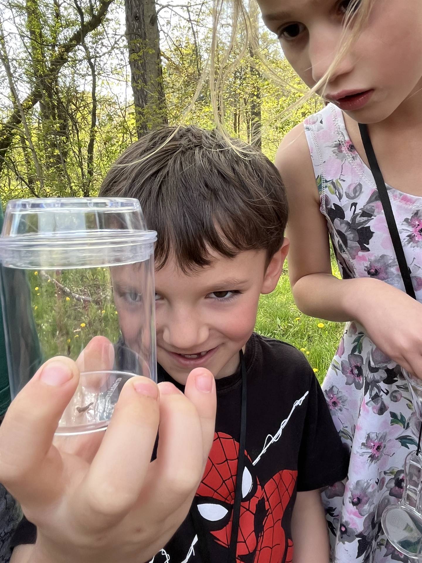 a student holds up a jar of nature items