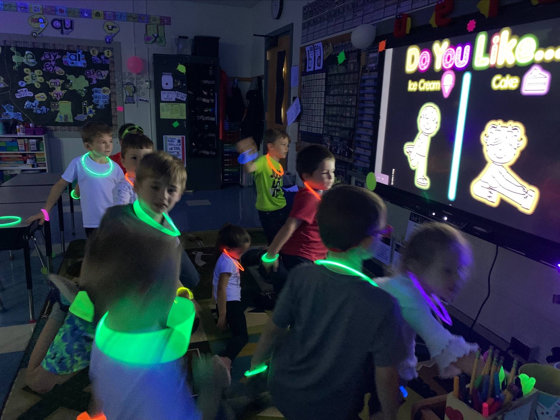 a teacher in a glowing neon shirt reads to her class