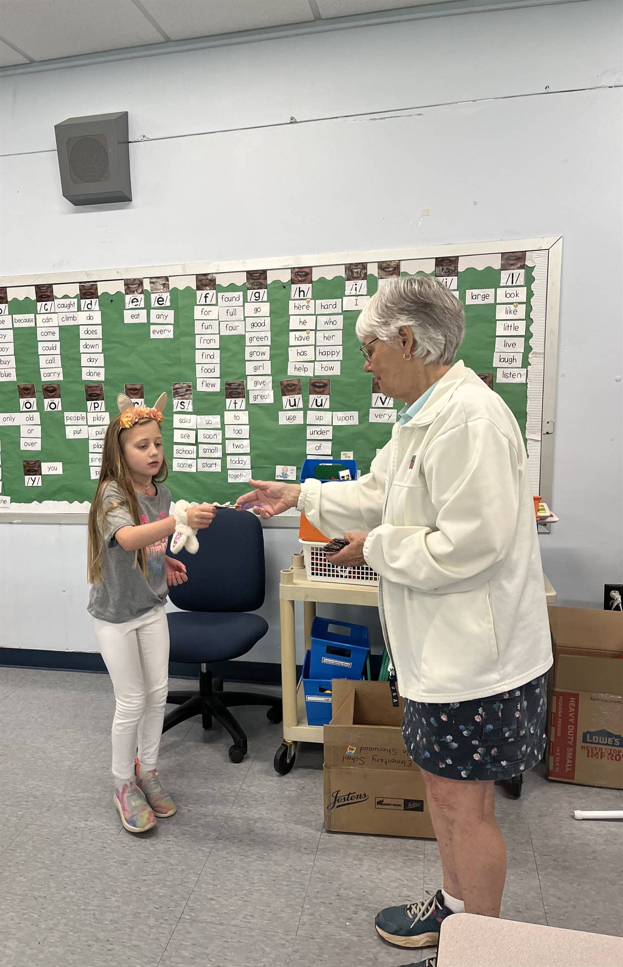 adult handing bookmark to student