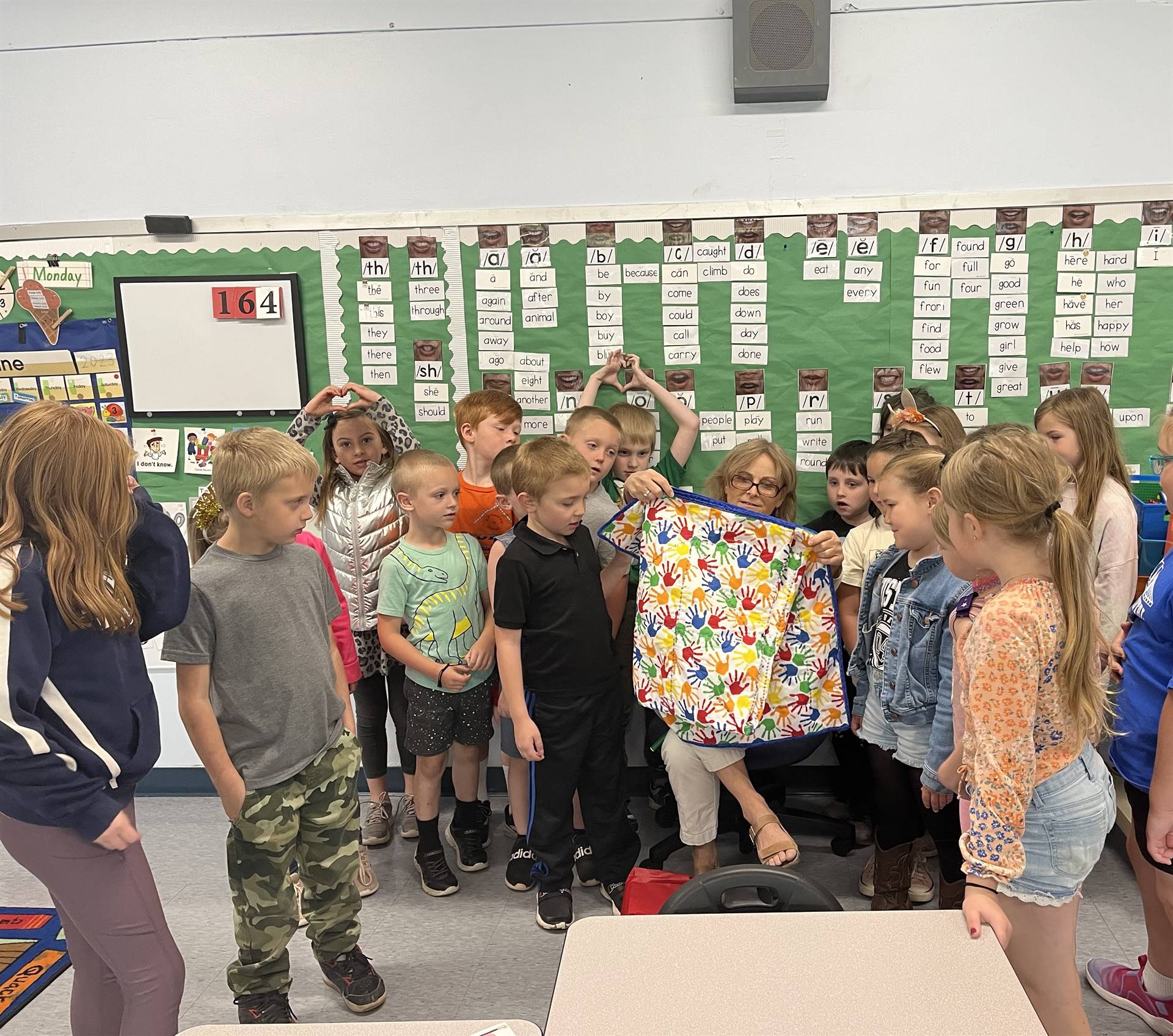 teacher with quilt and students around her