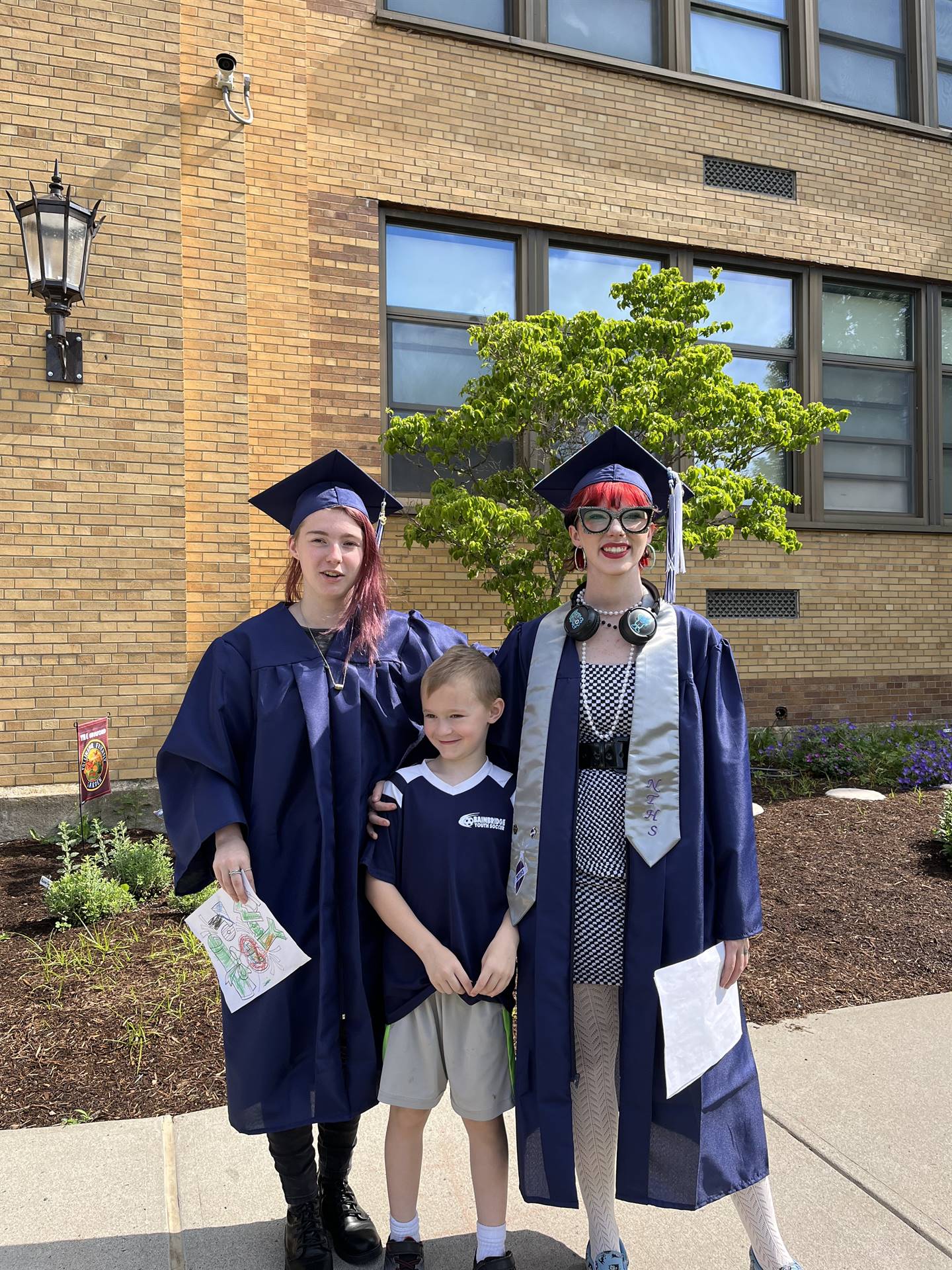Kindergarten student with his 2023 Senior graduate sister and another graduate