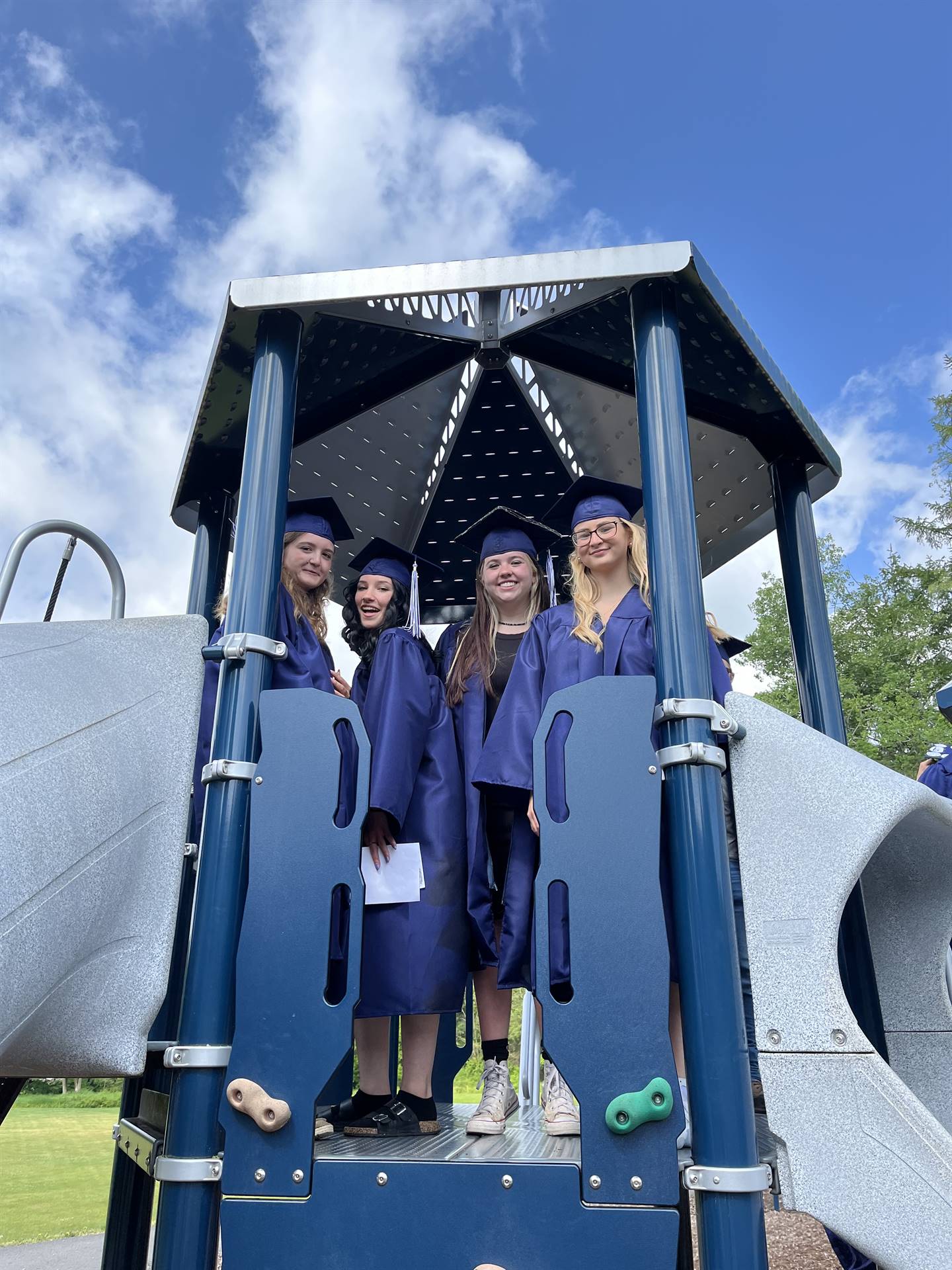 4 senior graduates on playground