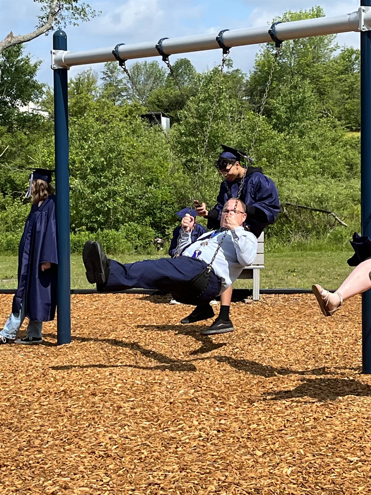 High School principal on playground swing