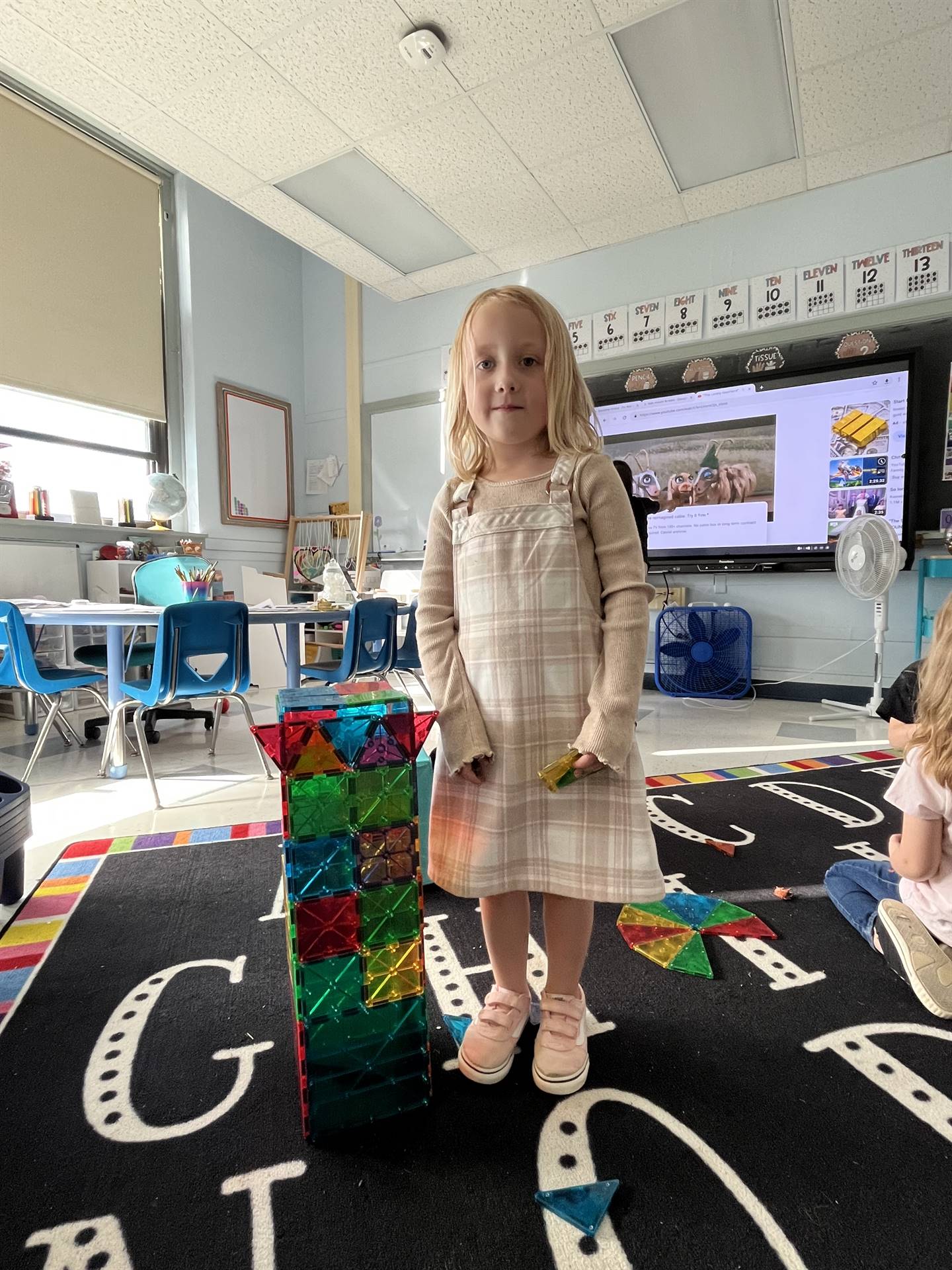 student next to self built magnetic tile tower