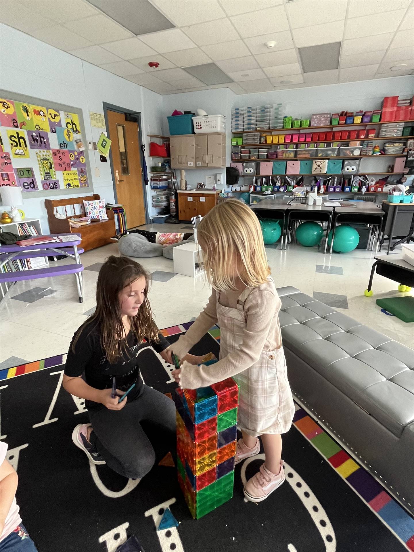 2 students building a magnetic block tower