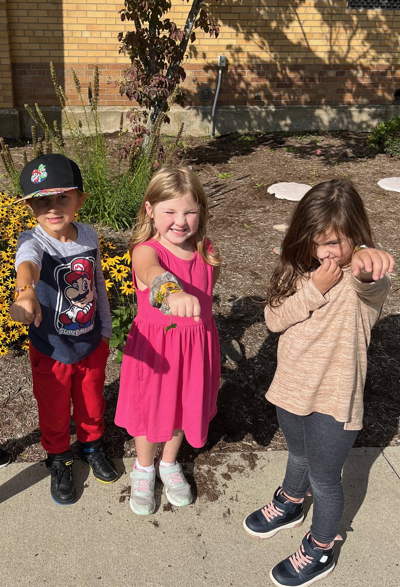 3 students outdoors showing their nature bracelets