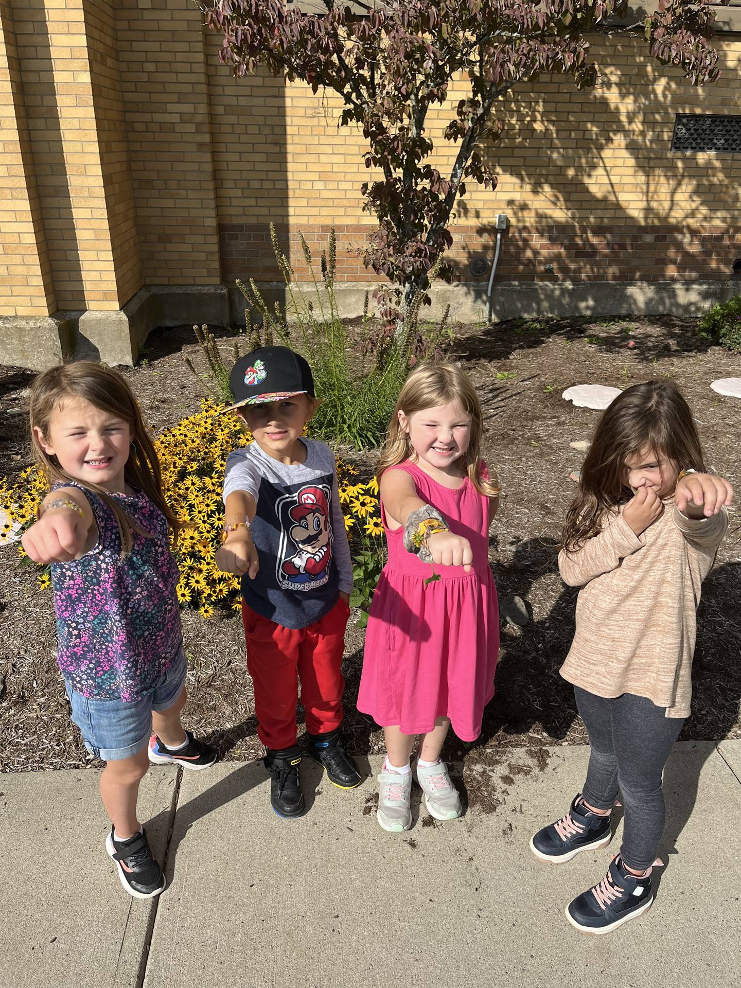 4 students outdoors showing their nature bracelets