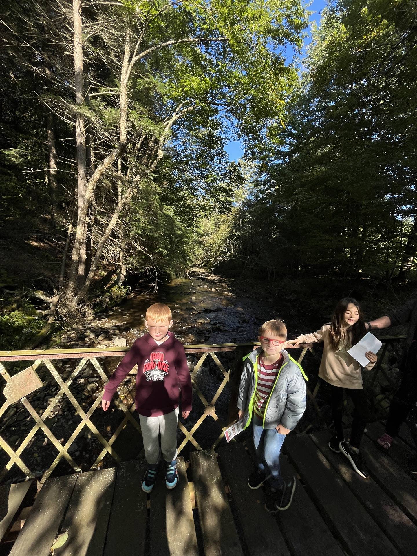 3 students walking across a bridge