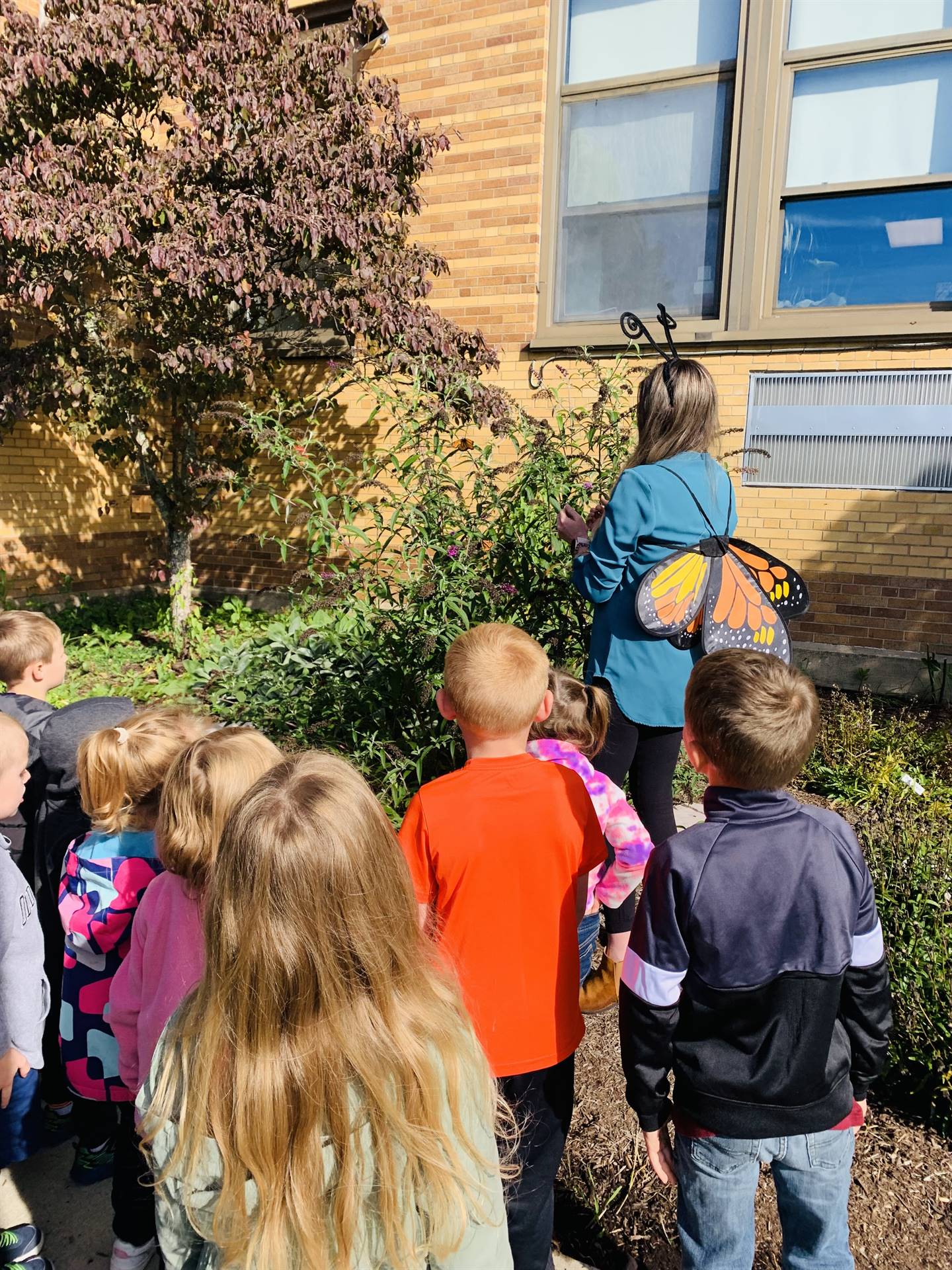 students and teacher in pollinator garden