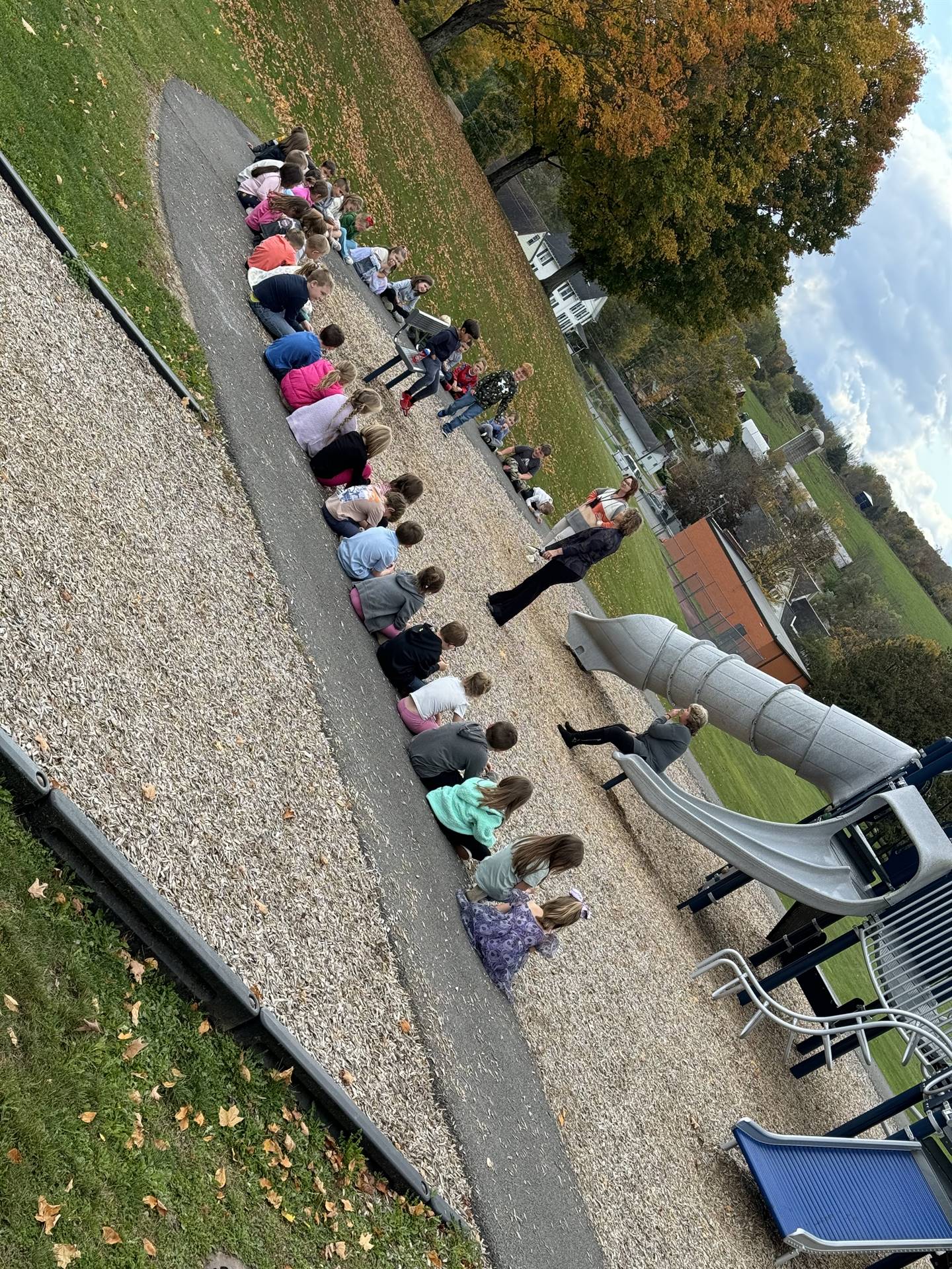 students seated outside on playground 