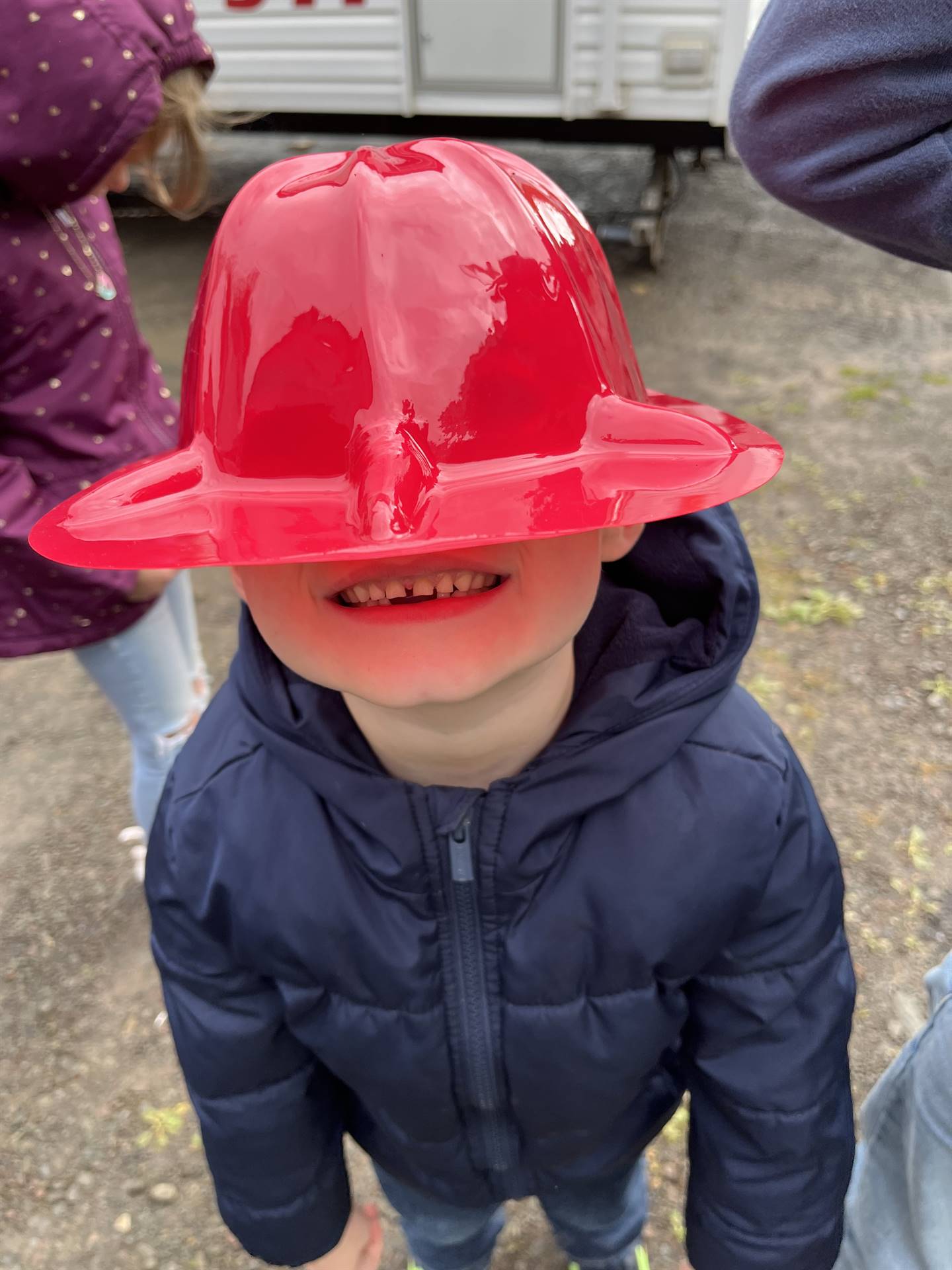 a student covers his face with a red fire helmet.